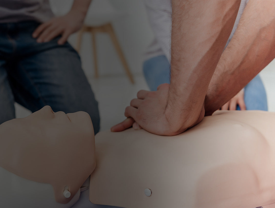 Person performing CPR on a mannequin during a training session.